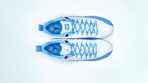 Side view of the UNC Tar Heels' blue and white Air Jordan cleats.